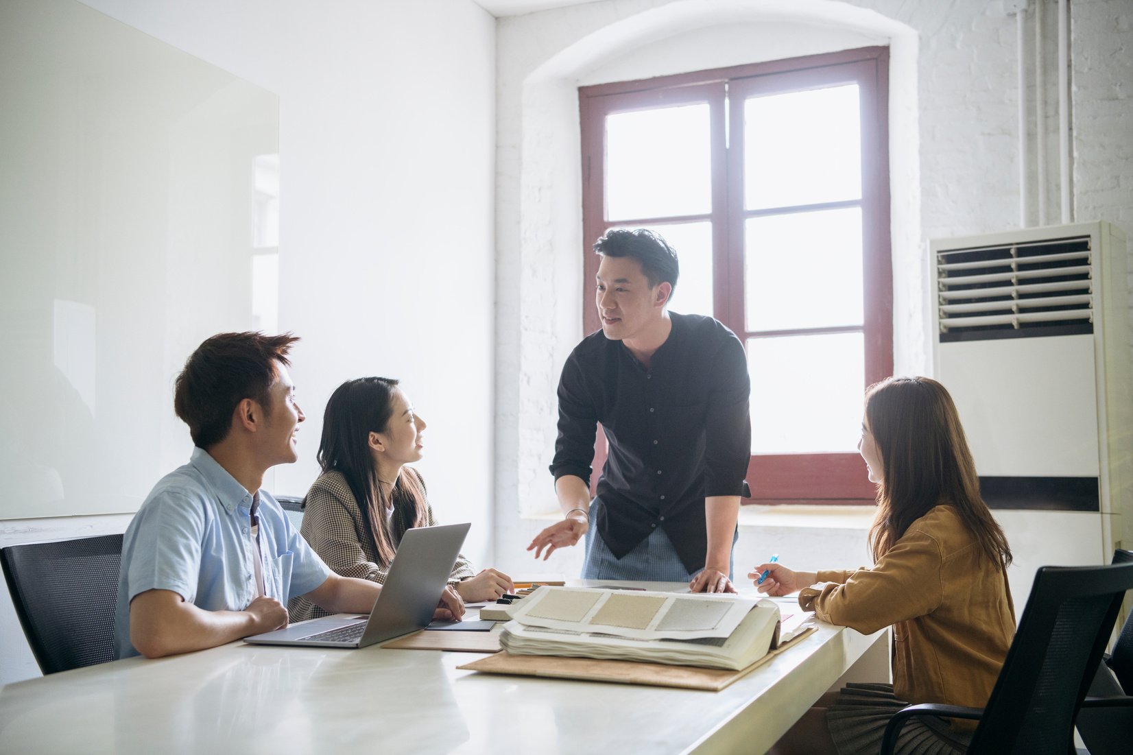 Young Chinese designer making sales pitch to colleagues